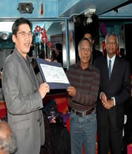captain khairuddin presenting a check to sk tye